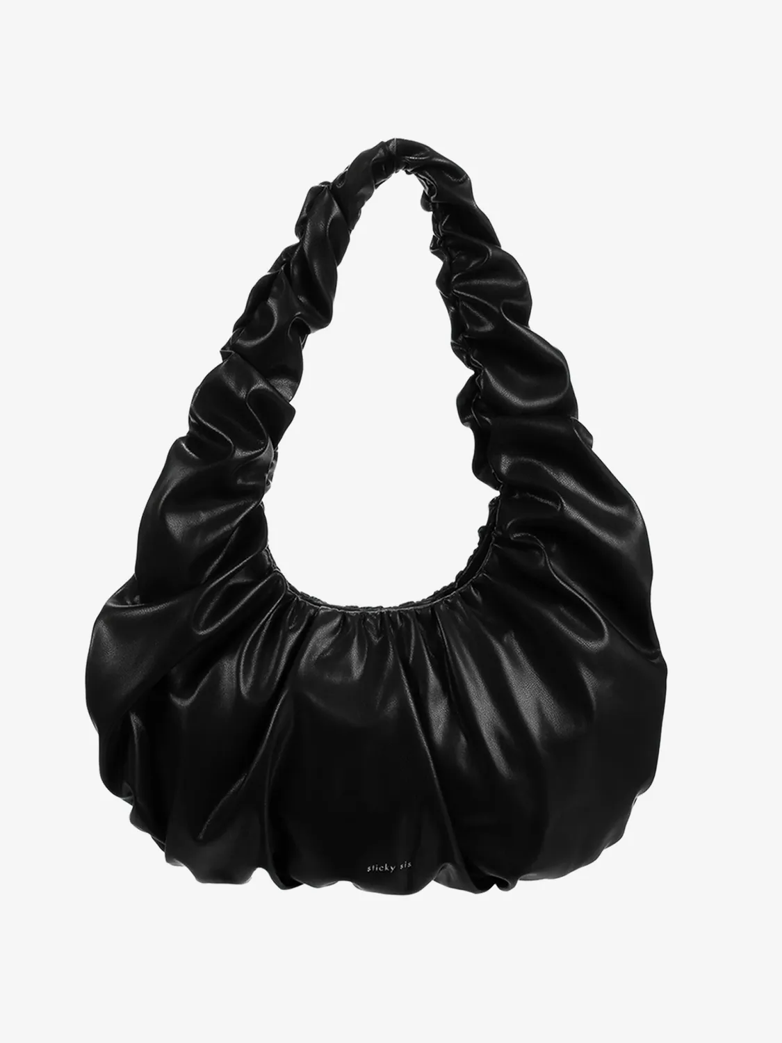 Den lille sorte, i croissant-fasong. Supermyk vegansk PU gir en glatt, luksuriøs finish, mens den buede silhuetten og rynket hank gjør vesken like chic til denim som til kjole. Innsiden er fôret med et tekstil med sorte dots og en praktisk lomme som holder småting på plass. Formatet er akkurat passe til dagene som flyter fra kaffe til kveldsplaner.