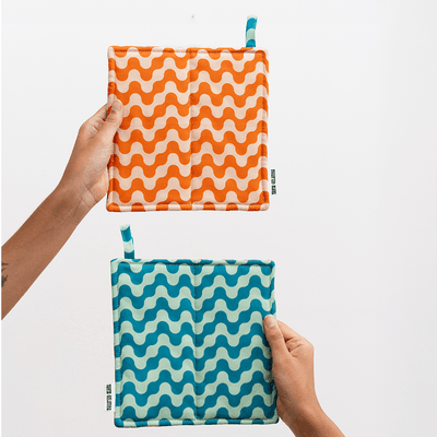 Vattert gryteklut i økologisk bomull med to ulike farger. Praktisk, dekorativ og designet for å henge fremme – ikke gjemmes bort.